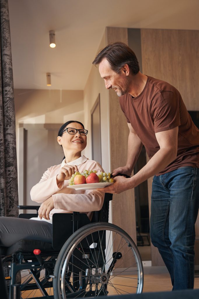 Smiling man bringing fruit for wife with paraleria
